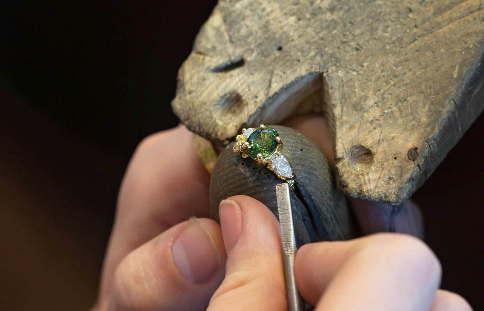 A selection of silver flower jewellery castings on a forge plate being heated up with a blowtorch.